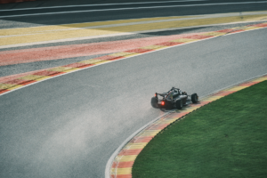A blacked out single seater car driving at spa gp circuit