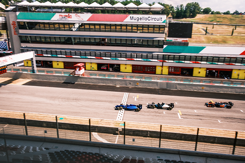 A shot of 3 single seater cars going over the start finish line at mugello circuit