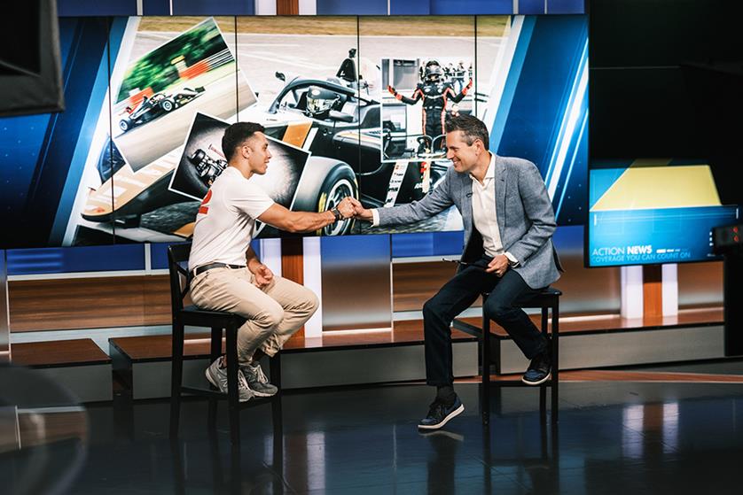 Shawn Rashid greeting the television interview host on the set of Action news while pictures from throughout Shawns career are shown behind him.